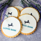 Several round biscuits decorated with the Lloyds Bank logo, arranged on a grey surface with lavender sprigs beside them.