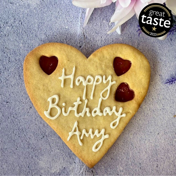 Giant personalised biscuit with "Happy Birthday Amy" piped in icing and three star-shaped jam cut-outs.