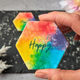 Colourful rainbow biscuits with 'happy' written on them.