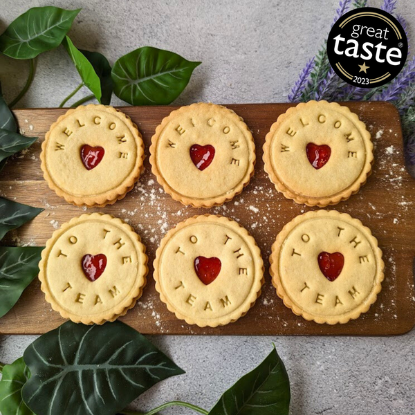 Onboarding gift of 6 jam biscuits with "Welcome to the team" message and heart-shaped cutouts.