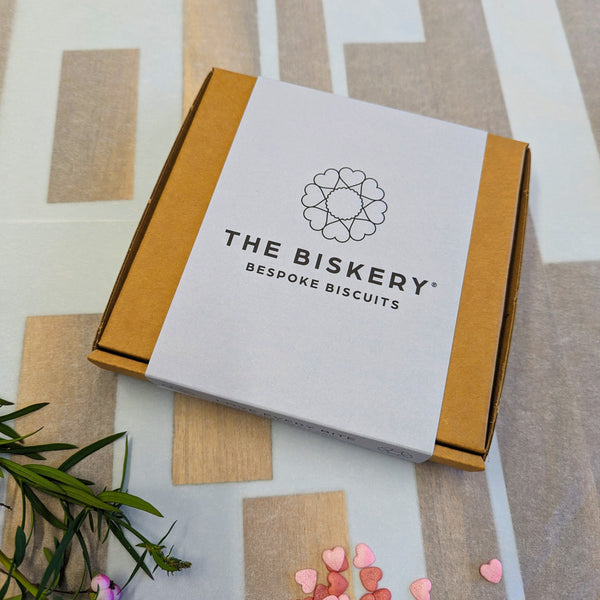 Boxes labelled 'The Biskery' and 'Bespoke biscuits' sit on a table, filled with Giant Personalised Cookie.