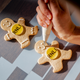 Hand decorating RNLI branded gingerbread man biscuits with white icing. 